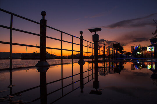 The image created by the reflection of the banisters on the beach at sunset.
