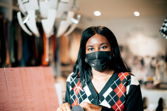 Portrait Of A Black Female Shopkeeper At Work Wearing A Protective Face Mask Against Viruses. New Normal Concept.