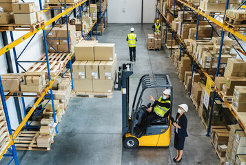 High-angle view of group of workers with manager working indoors in warehouse, coronavirus concept.