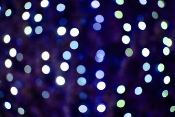 Blurred blue background of christmas lamps, dark bokeh of city new year light