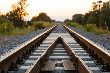 Fototapeta premium rails sleepers railway track at sunset of a summer day