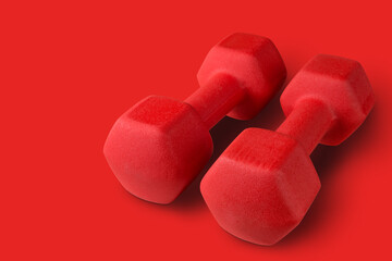 pair of big red dumbbells on red background, concept