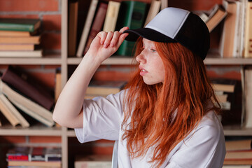 Portrait of a redhead woman in template blank t-shirt and cap with healthy freckled skin. Young...