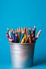 bucket with pencils on a blue background