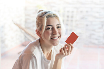 Blond woman holding blank business card for mock up