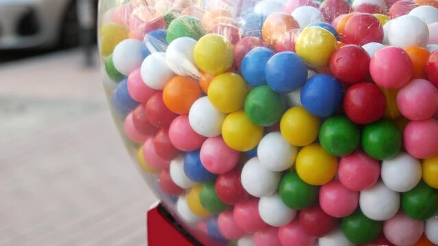 Colorful gumballs in classic vending machine, USA. Multi colored buble gums, coin operated retro dispenser. Chewing gum candies as symbol of childhood and summertime. Mixed sweets in vintage automate.