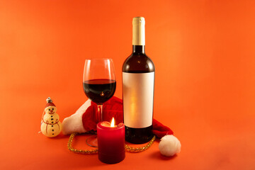 Wine bottle, glass and candle. A romantic Christmas evening
