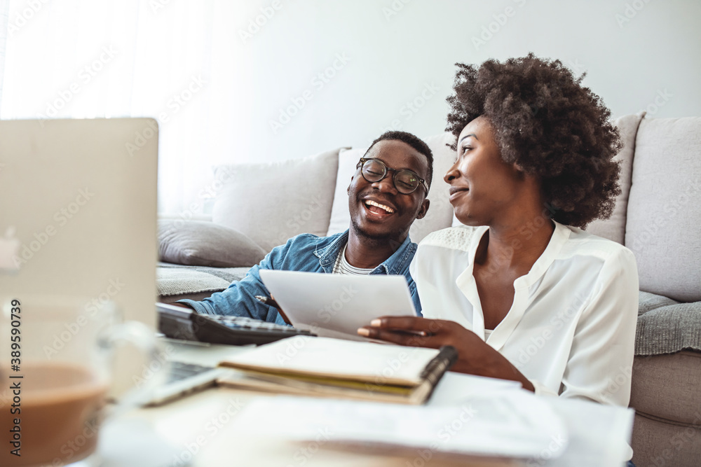 Wall mural young married couple doing their paperwork together, paying bills online. focus on the guy. loving y