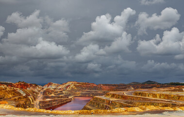 Copper mine under the dark cloudscape, wide angle