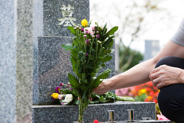 お墓に花を供える女性