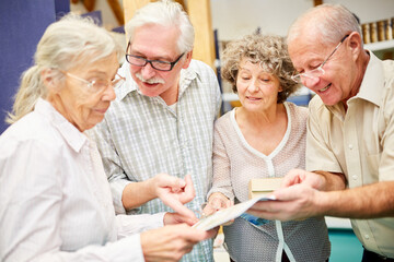 Group of seniors with book researching as a team - Powered by Adobe