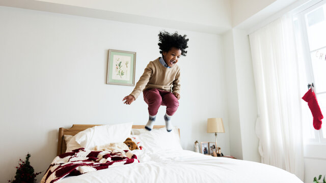 Young kid having a fun time jumping on the bed