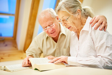 Senior couple in retirement home reading in a book