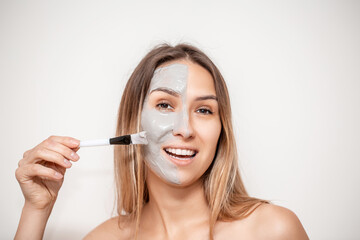 Facial Skin Care. pretty smiling woman covered with moisturizing alginate mask with chitosan, allantoin, marine collagen. Beautiful Woman Getting Cosmetic Mask