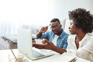 Fototapeta na wymiar Serious worried african american couple reading documents consider mortgage loan insurance contract terms, focused black man and woman holding checking bank papers at home, domestic bills concept