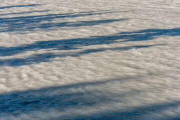 shadows on the surface of a silt loaden river