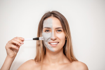 The cosmetologist for procedure of cleansing and moisturizing the skin, applying a Alginic mask to the face of a young woman. Beauty facial mask, skin care and treatment concept