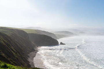 green grassy cliffs drop down to the ocean coast in northern Spain