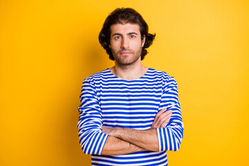 Photo of serious young middle eastern man sailor cross hands look in camera isolated over vivid yellow color background