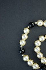 Old vintage necklace with pearl laying isolated on dark grey background,fashion flat lay with retro bijouterie,print as postcard for mothers and womens day,greeting card,free place for text,copy space