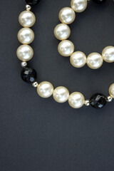 Old vintage necklace with pearl laying isolated on dark grey background,fashion flat lay with retro bijouterie,print as postcard for mothers and womens day,greeting card,free place for text,copy space