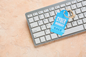Computer keyboard and shopping tag with text CYBER MONDAY SALE on color background