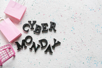 Shopping cart with bags and text CYBER MONDAY on white background
