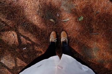 Girl looking to the her brown leather shoes close up 