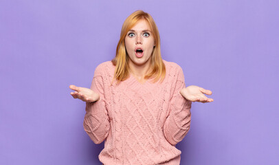 red head pretty woman open-mouthed and amazed, shocked and astonished with an unbelievable surprise