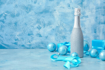 Christmas composition with bottle of champagne on color background