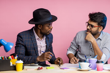 Two businessmen speaking and working at the office