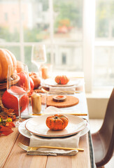 Beautiful table setting with pumpkins in dining room