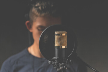 Studio microphone for sound recording. The singer in the background blurred background. Low key lighting