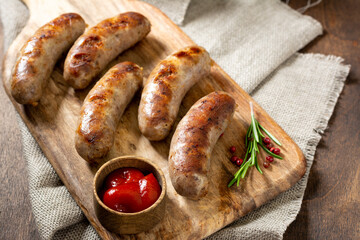 Fried sausages. Grilled sausages with spices on a wooden serving Board. Delicious meat sausages