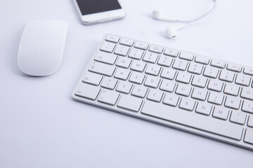 new modern keyboard with computer mouse and smartphone with earphones isolated on white background, close view . High quality photo