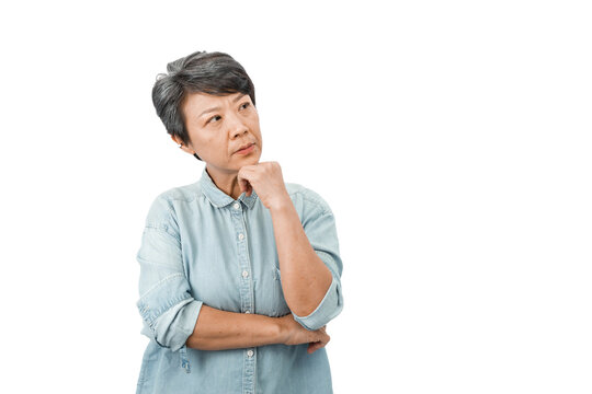 A Middle-aged Gray-haired Asian Woman Puts Her Hand Under Her Chin. Doubt And Confused, Thinking About An Idea Or Worrying About Something On A White Background. Concept About The Elderly