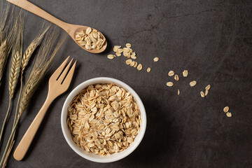 Oat flakes in white bowl top view. Concept healthy eating, dieting and vegetarian food.