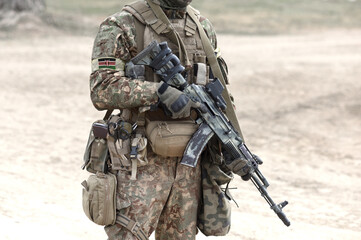 Soldier with assault rifle and flag of Kenya on military uniform. Collage.