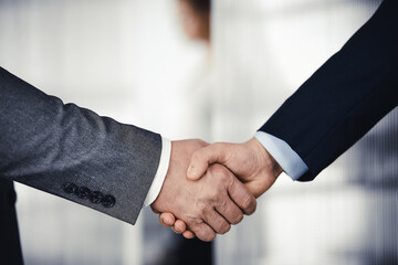 Business people in office suits standing and shaking hands, close-up. Business communication concept. Handshake and marketing