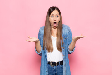 young pretty woman feeling extremely shocked and surprised, anxious and panicking, with a stressed...