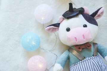Cute cow with christmas garland - symbol of the new year 2021. Soft toy