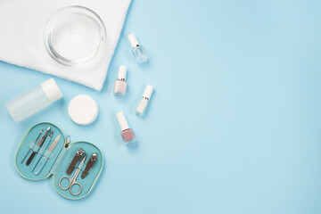 Spa set equipment for manicure or pedicure with nail coat or polish, on blue background, horizontal, copy space, top view