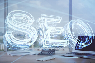 Multi exposure of table with computer and seo drawing hologram. Search optimization concept.