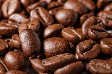 Freshly roasted coffee beans background.Dark roasted coffee beans with scoop on wooden background.