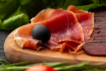 Wooden platter with meat cuts close up