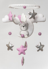 Baby crib mobile - kids toys, on light background.