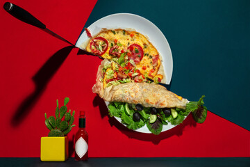 Omelet on pita bread with vegetables and bacon, cut in half by a knife along with a plate. In the foreground cactus and chilli sauce. Mexican food. Plane distortion