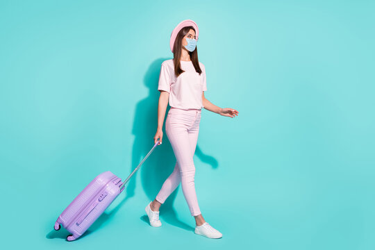 Full length photo of girl walking suit departure flight wear safety medical mask isolated turquoise color background