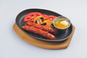 Grilled barbecue sausages and mushrooms in the pan with mustard dip sauce. Fast food concept.