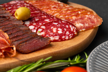 Wooden platter with meat cuts close up